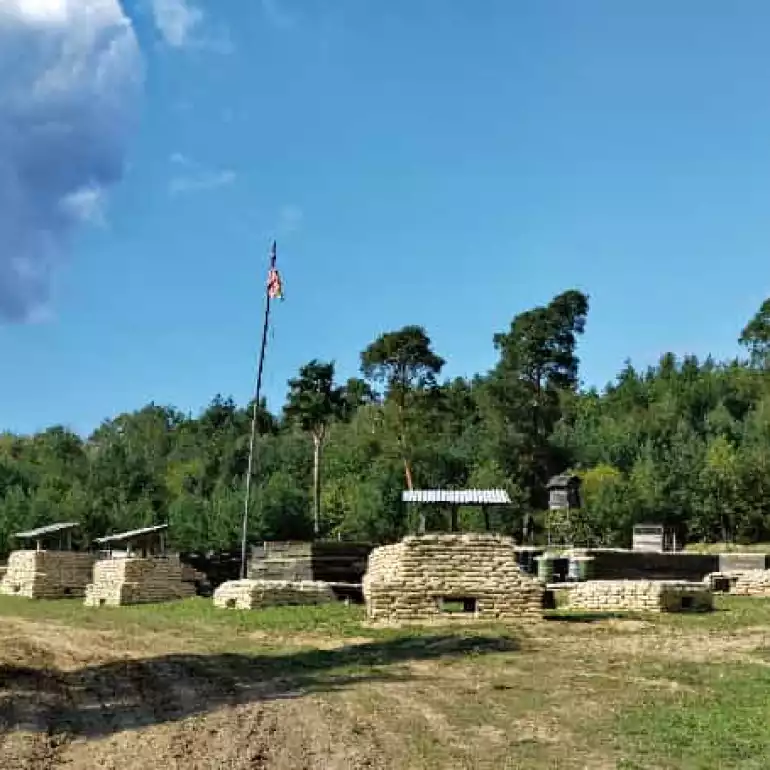 Multiple military vehicles parked at an outdoor tank range.