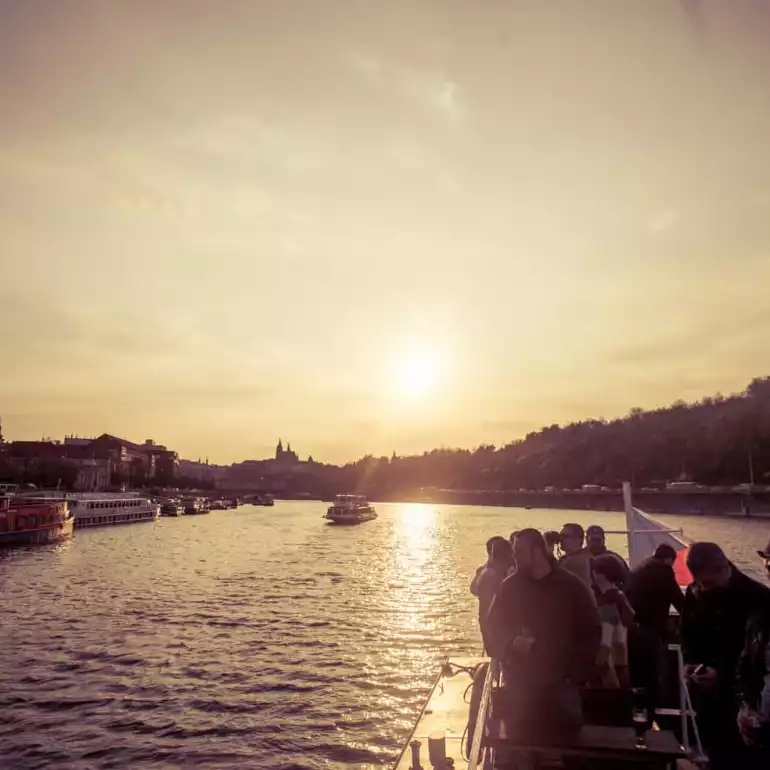 A boat sailing the river during the sunset.